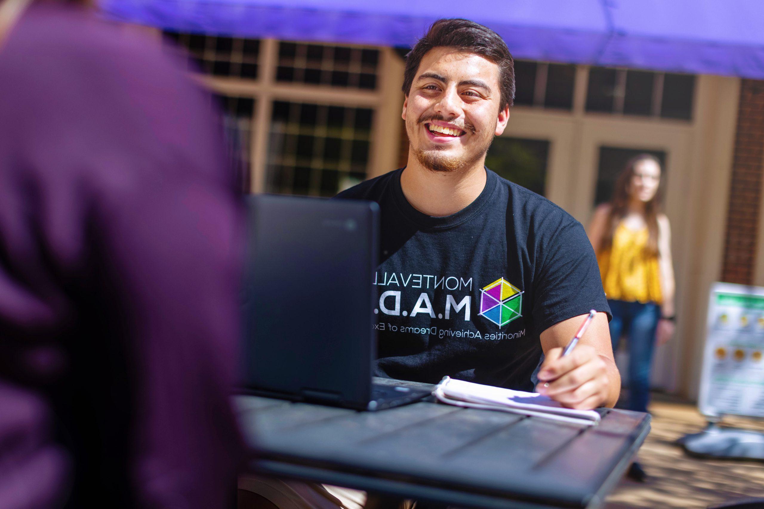 A University of Montevallo student smiles during a conversation with a friend during a conversation on the Farmer Hall patio.